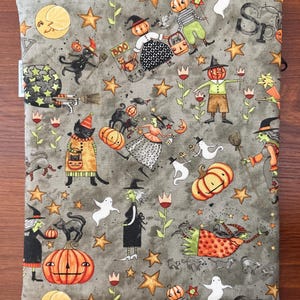 May include: Gray fabric with a Halloween-themed pattern featuring pumpkins, witches, cats, ghosts, stars, and the word "Boo". The design includes a crescent moon, tulips, and various Halloween characters.