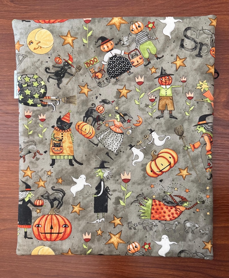 May include: Gray fabric with a Halloween-themed pattern featuring pumpkins, witches, cats, ghosts, stars, and the word "Boo". The design includes a crescent moon, tulips, and various Halloween characters.