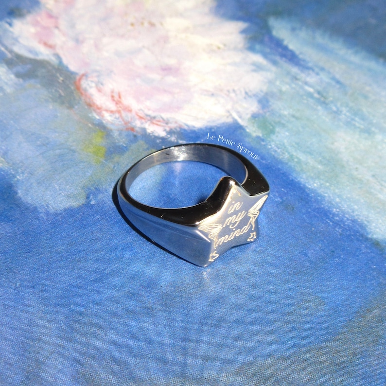 Pu&ograve; includere: Un anello d'argento con un design a forma di stella. La stella &egrave; incisa con le parole "in my mind".