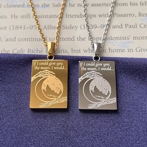 May include: Two silver necklaces with rectangular pendants. The pendants feature a crescent moon, stars, and skeletal hands with the text "If I could give you the moon, I would..." on each. One pendant is gold and the other is silver.