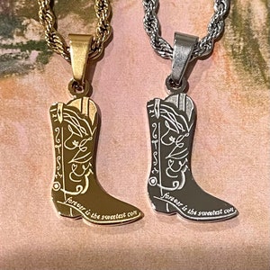 Puede incluir: Dos collares de oro y plata con colgantes de botas de vaquero. Los colgantes tienen grabadas las palabras "forever is the sweetest con".