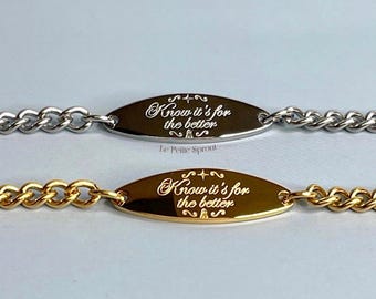 May include: Two bracelets, one silver-toned and one gold-toned, each featuring a chain link design. The oval-shaped centerpieces are engraved with the phrase "Know it's for the better" in elegant script. The bracelets are displayed on a light gray background.