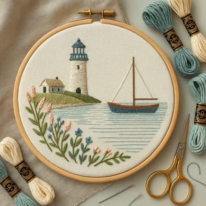 Può includere: Un ricamo di un faro e una barca a vela in un telaio di legno. L'opera presenta un faro bianco con la parte superiore blu, una piccola casa e una barca a vela blu su uno sfondo di acqua azzurra. Fiori rosa e blu e fogliame verde circondano la parte inferiore.