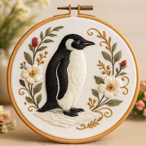 Peut inclure: Broderie d'un manchot dans un cercle en bois. Le manchot est noir et blanc, entouré de fleurs blanches, de boutons rouges et de feuillage vert et doré. Le texte "Hand Embroidery PDF Patterns by Zazarita" est en bas.