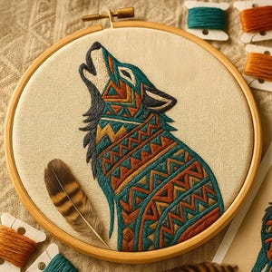 Peut inclure: Broderie d'art en forme de loup hurlant, ornée de motifs géométriques en turquoise, orange et jaune. L'œuvre est encadrée dans un cercle à broder en bois, avec une plume et des bobines de fil à proximité. Le loup est brodé sur un tissu beige.