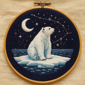 May include: Hand-embroidered artwork featuring a polar bear on an ice floe beneath a night sky with stars and a crescent moon, set in a wooden hoop. The bear is white, the sky is dark blue, and the ice is light blue. The embroidery is in a wooden hoop.