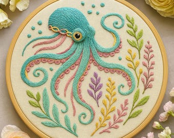 May include: A hand-embroidered octopus design in a wooden hoop. The octopus is teal with pink and teal tentacles, and a gold-colored eye. The design includes colorful embroidered seaweed and bubbles on a cream-colored background. The text "Hand Embroidery PDF Patterns by Zazarita" is at the bottom.