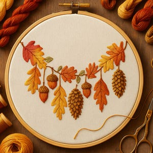 Può includere: Un telaio da ricamo con tessuto color crema con un design a tema autunnale. Il design ricamato include foglie, ghiande e pigne nei toni dell'arancione, giallo e marrone. Il telaio è circondato da rocchetti di filo e forbici dorate.
