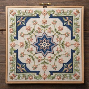 Può includere: Telaio da ricamo quadrato con un design floreale dettagliato. Il motivo centrale è una stella a otto punte nei toni del blu e del rosa. Il bordo e gli angoli sono adornati da fiori rosa e foglie verdi, su uno sfondo neutro.