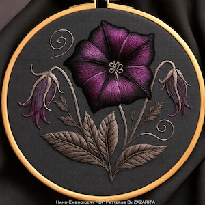 May include: Hand-stitched floral embroidery on black fabric, set in a wooden hoop. The design features a large, vibrant purple flower with detailed shading, accompanied by smaller buds and leaves in shades of brown and purple. The text at the bottom reads "Hand Embroidery PDF Patterns By Zazarita."