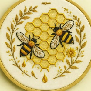 May include: Embroidered artwork featuring two bees with black and yellow stripes, set against a yellow honeycomb. The design includes golden leaves, a flower, and droplets, all within a wooden embroidery hoop.