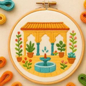 May include: A detailed embroidery hoop art piece featuring a yellow gazebo with teal columns and a turquoise fountain. Potted plants and flowers in orange and green are placed around the gazebo. The embroidery is set in a wooden hoop.