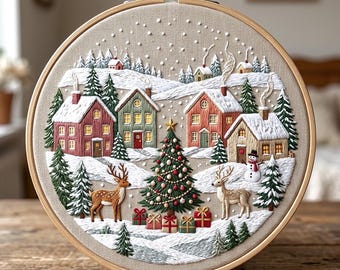 May include: A circular embroidery hoop featuring a winter village scene on beige fabric. The design includes red, green, and tan houses, a decorated Christmas tree with gifts, two deer, a snowman, and evergreen trees under falling snow.