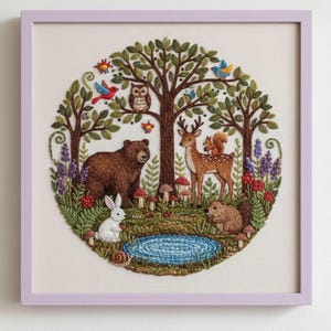 May include: Embroidered artwork in a lavender frame. The circular design features a forest scene with a bear, deer, squirrel, rabbit, and beaver. Trees, flowers, mushrooms, and a pond are also included. Birds and an owl are perched in the trees.