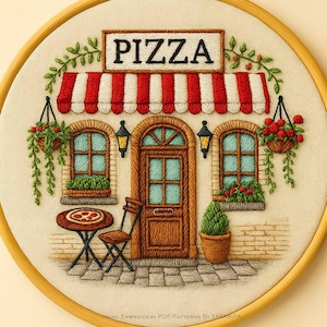 May include: Embroidered hoop art featuring a pizza shop scene. The design includes a red and white striped awning, a door, windows, and a table with a pizza. The word "PIZZA" is displayed above the awning. Green vines and hanging flower baskets add detail.
