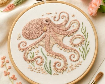 May include: Hand-stitched embroidery art featuring a pink octopus with detailed tentacles, surrounded by green seaweed and small beige embellishments. The design is set within a wooden embroidery hoop. The text "Hand Embroidery PDF Patterns By Zazarita" is at the bottom.