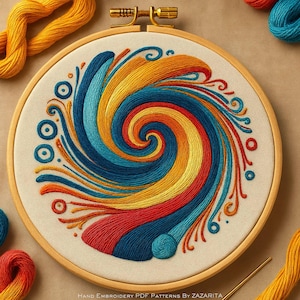 May include: A colorful embroidery hoop with a swirling design in shades of blue, yellow, orange, and red. The design is centered on a cream-colored fabric, held within a wooden hoop. The text "Hand Embroidery PDF Patterns By Zazarita" is at the bottom.