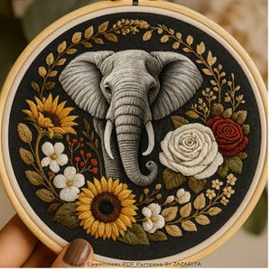 May include: Embroidered elephant design in a wooden hoop. The elephant is grey, surrounded by sunflowers, roses, and other floral elements in shades of yellow, white, and red against a black background. The text "HAND EMBROIDERY PDF PATTERNS BY ZAZARITA" is at the bottom.