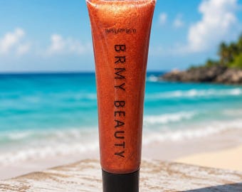 May include: A squeeze tube of copper-toned shimmer lip gloss with a black cap. The tube features the text BRMY BEAUTY printed vertically in black, along with the volume measurement of 0.5 fl oz/15 ml printed near the top clear plastic seal.