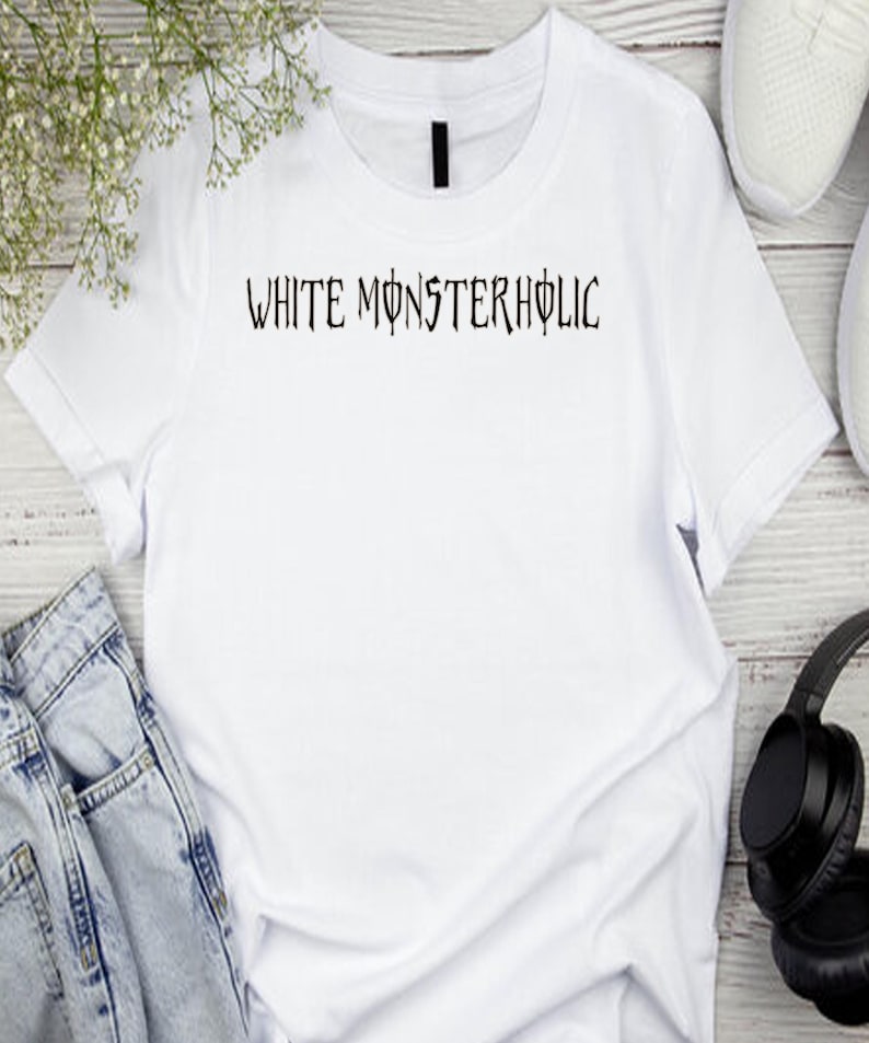 May include: White t-shirt featuring the text "WHITE MONSTERHOLIC" in a gothic font. The shirt is shown with blue jeans, white trainers, and black headphones. The shirt is made of a soft, white material.
