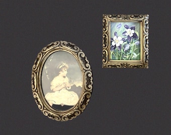 May include: Two decorative wall frames with ornate metallic gold-toned borders. The oval frame contains a portrait of a person in a white garment. The rectangular frame features a painted illustration of purple and white columbine flowers.