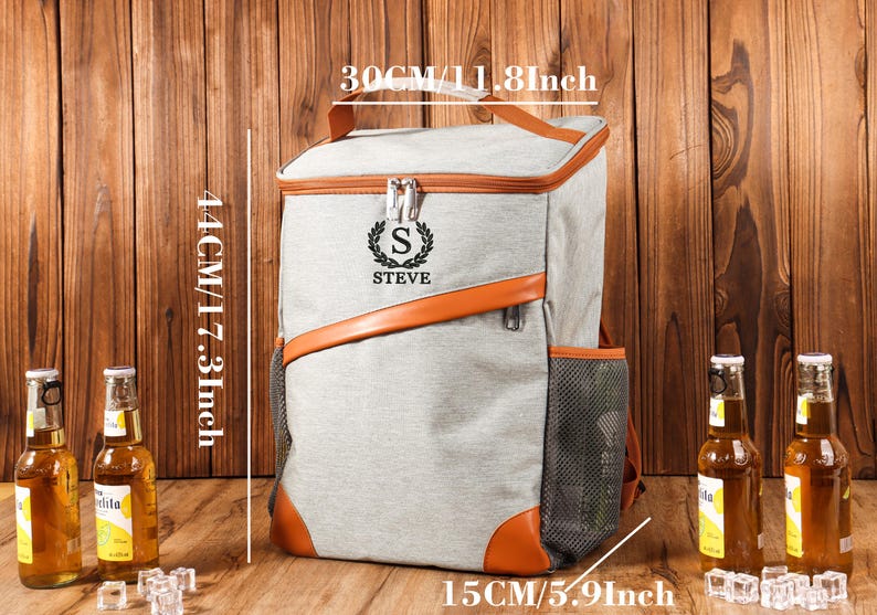 Pu&ograve; includere: Zaino termico grigio con dettagli in pelle marrone, misura 44 cm di altezza, 30 cm di larghezza e 15 cm di profondit&agrave;. Presenta una tasca laterale in rete e il nome "STEVE" con l'iniziale "S".