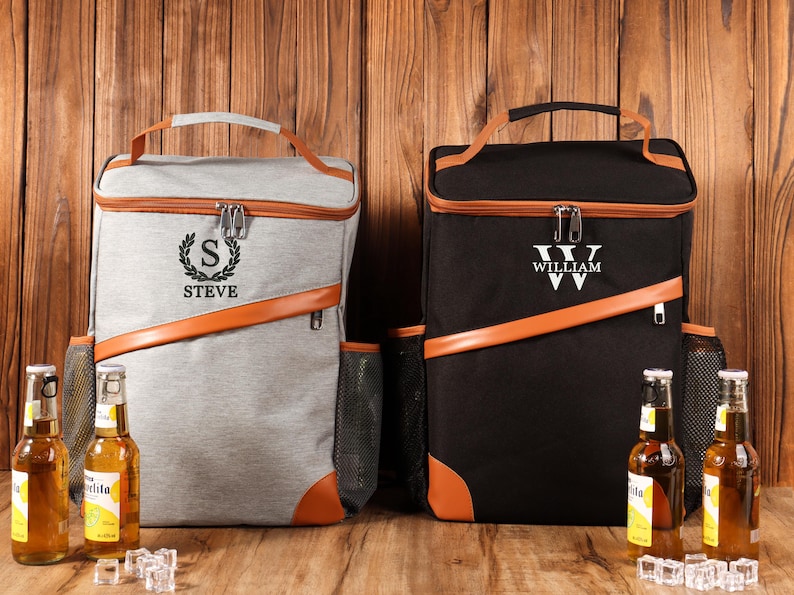 Pu&ograve; includere: Due zaini frigo personalizzati, uno grigio e uno nero, con dettagli marroni. Lo zaino grigio ha "STEVE" e un design a corona d'alloro, mentre quello nero ha "WILLIAM". Entrambi hanno una maniglia superiore e tasche laterali in rete.