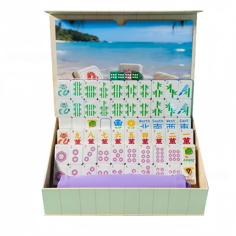 May include: A complete Mahjong set in a wooden box. The set includes white tiles with various symbols and numbers, green dice, and a purple tile holder. The box has a beach scene on the inside.