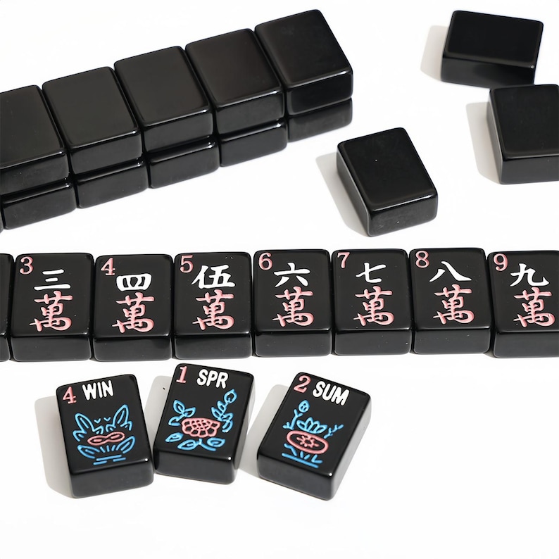 May include: A collection of black Mahjong tiles with white and pink characters. Some tiles are stacked, while others are scattered. The tiles feature numbers and symbols, including "WIN", "SPR", and "SUM".