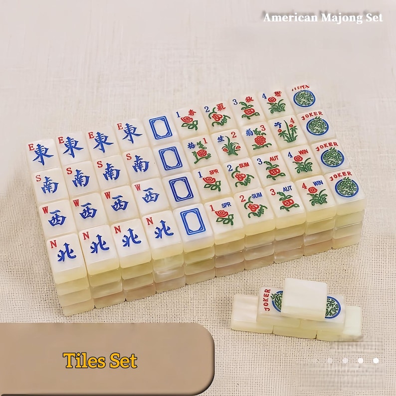 May include: An American Majong set featuring off-white rectangular tiles with blue and red ink designs. The tiles display directional characters, floral motifs, seasonal labels, and Joker tiles. The text American Majong Set is visible.