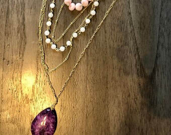 Naszyjnik z wieloma łańcuszkami i fioletowymi kamieniami oraz pasujące kolczyki