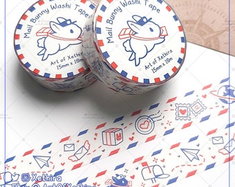 May include: Two rolls of white washi tape with a blue and red border. The tape features a cartoon bunny wearing a blue cap and carrying a package. The text on the tape reads "Mail Bunny Washi Tape" and "Art of Xethira 15mm x 10m".