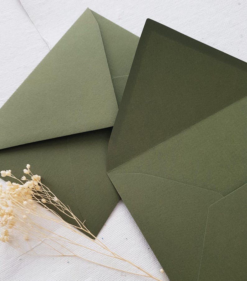 May include: Two green envelopes with a textured finish. The envelopes are folded and ready to be sealed.