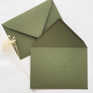 May include: Two green envelopes, one on top of the other, with the top envelope folded over the bottom envelope.