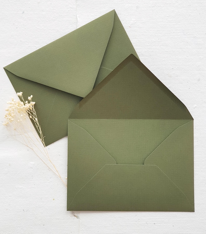 May include: Two green envelopes, one on top of the other, with the top envelope folded over the bottom envelope.