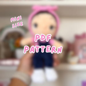 May include: A handmade doll with a pink headband and overalls. The doll has a light skin tone and is wearing a pink shirt. The text "MINI SIZE" and "PDF PATTERN" are displayed on the image.
