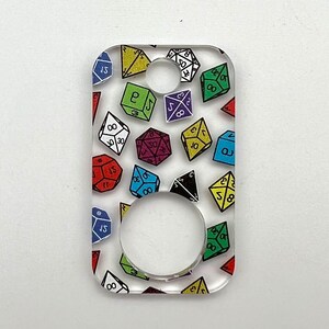 May include: A clear acrylic keychain with a colorful pattern of dice. The dice are various colors and have different numbers on them. The keychain has a large hole in the center.