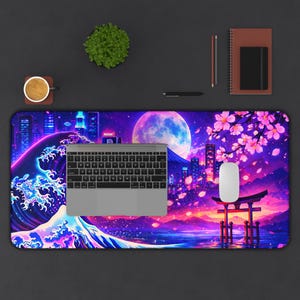 Könnte beinhalten: Eine große, rechteckige Schreibtischunterlage mit einem japanisch inspirierten Design. Das Kunstwerk zeigt eine große Welle, eine Skyline, einen Vollmond und Kirschblüten in Lila-, Blau- und Rosatönen. Eine Tastatur und eine Maus befinden sich auf der Unterlage.