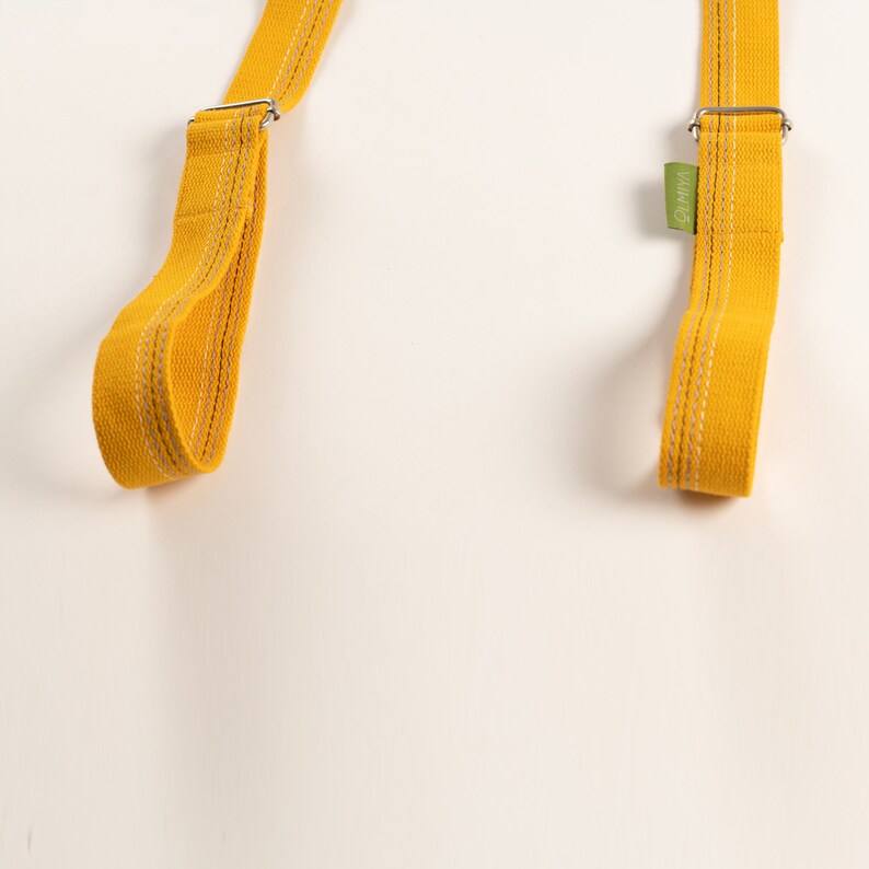 May include: Two yellow cotton straps with white stitching and silver metal buckles. The strap on the right has a green label with the text "WMW".
