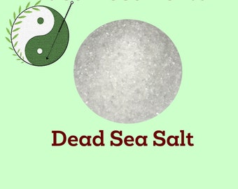 May include: A close-up of white Dead Sea salt crystals in a round container. The label reads "East West Herbal" and "Dead Sea Salt".