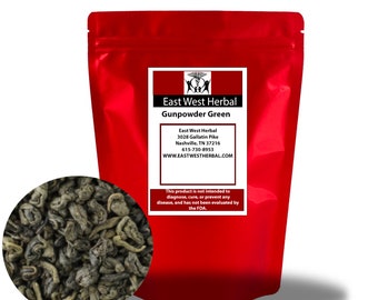 May include: A red resealable bag of East West Herbal Gunpowder Green tea. The bag has a white label with the company name, address, and phone number. The text on the label reads: "This product is not intended to diagnose, cure, or prevent any disease, and has not been evaluated by the FDA."