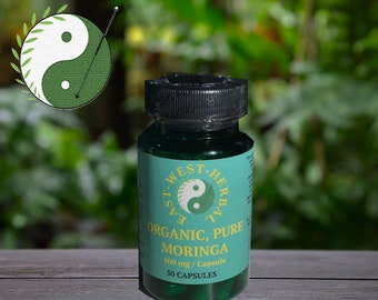 May include: A green bottle with a black lid and a white label that says "East West Herbal" and "Organic, Pure Moringa". The label also says "500 mg/Capsule" and "50 Capsules".