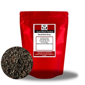 Könnte beinhalten: Ein wiederverschließbarer roter Beutel mit East West Herbal Decaf Earl Grey Tee. Der Beutel hat ein weißes Etikett mit dem Firmennamen, der Adresse, der Telefonnummer und der Website. Das Etikett enthält auch den Text "Dieses Produkt ist nicht dazu bestimmt, Krankheiten zu diagnostizieren, zu heilen oder zu verhindern, und wurde nicht von der FDA bewertet."