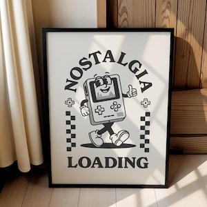 May include: Black framed poster with a retro cartoon graphic of a walking handheld game console giving a thumbs up. The words "NOSTALGIA LOADING" are in a circular design around the character. The background is off-white.