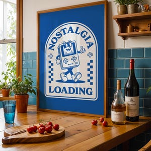 May include: A framed blue poster with the word "NOSTALGIA" and a cartoon video game character. The poster is on a wooden table with a cutting board of cherries, a glass of water, and wine bottles.