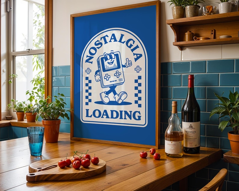 May include: A framed blue poster with the word "NOSTALGIA" and a cartoon video game character. The poster is on a wooden table with a cutting board of cherries, a glass of water, and wine bottles.