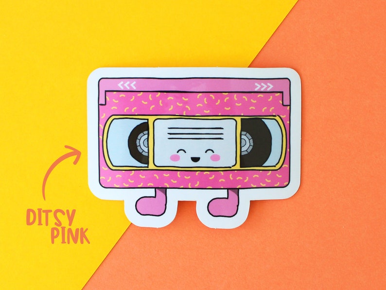 May include: A pink and yellow retro VHS cassette tape sticker with a smiling face and legs. The sticker has a 90s style pattern.