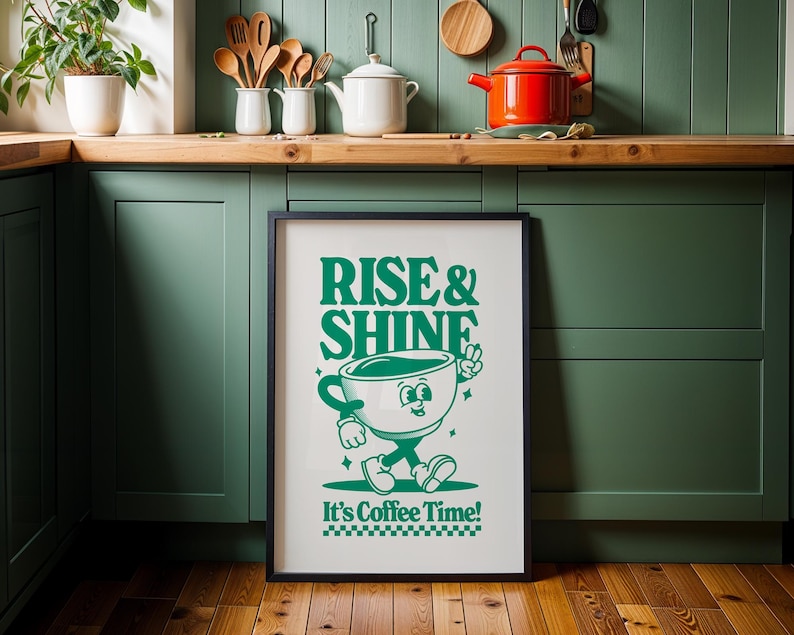 May include: A framed green and white poster with the text "Rise & Shine" and a cartoon coffee cup with a face and arms. The text "It's Coffee Time!" is below the cartoon coffee cup.
