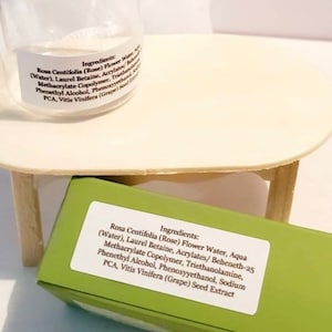May include: A green and white label with the ingredients for a rose water toner. The ingredients include Rosa Centifolia (Rose) Flower Water, Aqua (Water), Laurel Betaine, Acrylates/Beheneth-25 Methacrylate Copolymer, Triethanolamine, Phenethyl Alcohol, Phenoxyyethanol, Sodium PCA, Vitis Vinifera (Grape) Seed Extract.
