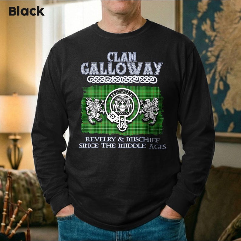 May include: Black long-sleeve shirt with the text "Clan Galloway" above a green and white plaid design. The design includes a crest with the word "Higher" and the phrase "Revelry & Mischief Since The Middle Ages."
